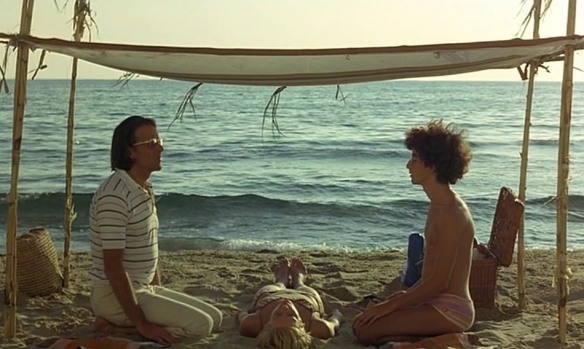 A father (Francois Simon, left) and son (Giovanni Rosselli) become entranced with an unconscious woman (Mimsy Farmer) they discover on a beach in Corpo d'amore (1972, aka Body of Love).